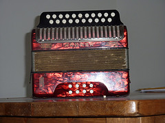 A red shiny button accordion